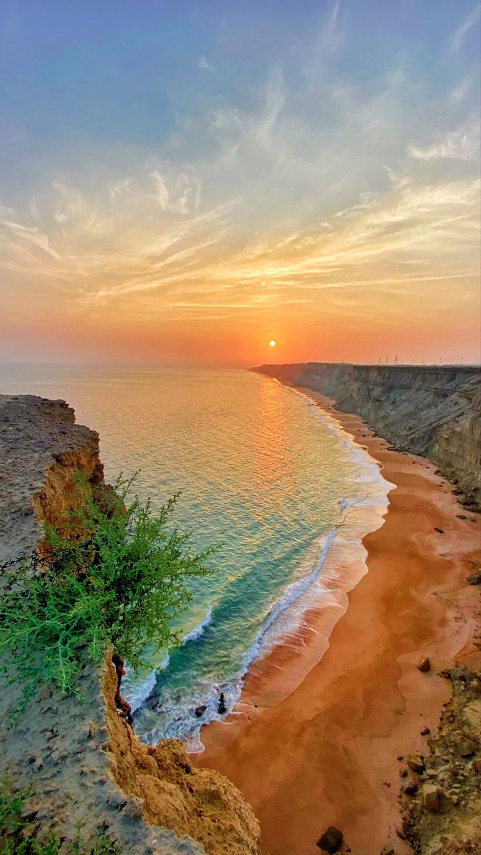 Sunset over the sea and a rugged coastal cliff